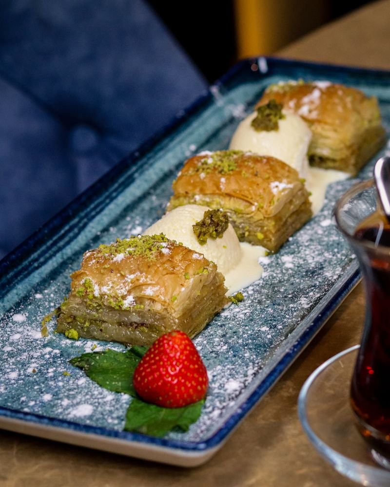Pistachio baklava with strawberry and a glass of Turkish tea
