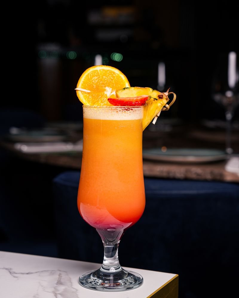 Tequila Sunrise style cocktail garnished with orange