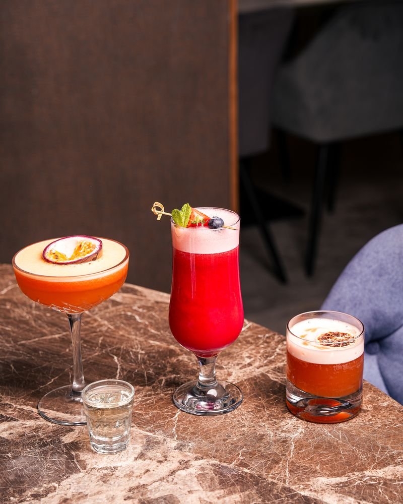 Three cocktails on the marble bar top at Turkoman