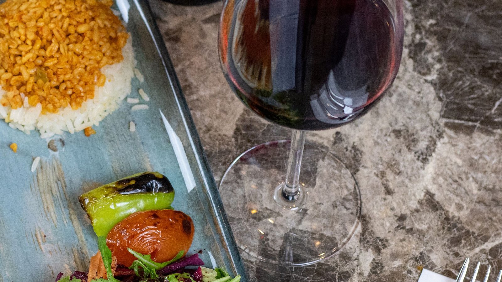 Lamb beyti with rice, salad and a glass of red wine at Turkoman Bar & Grill