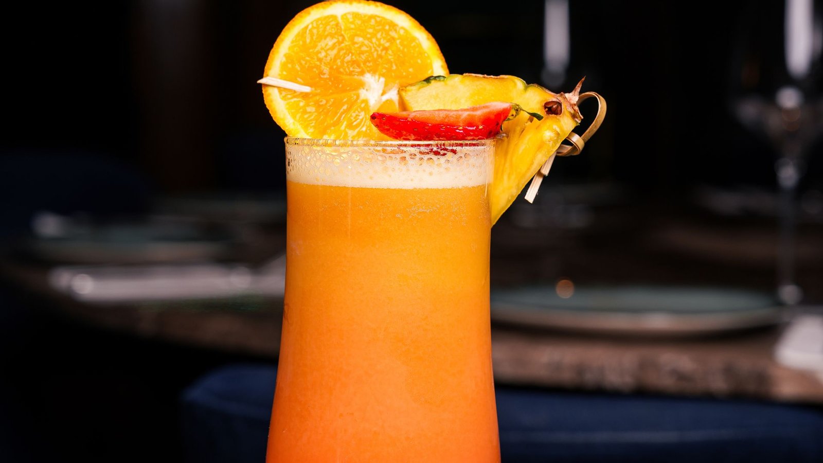 A layered cocktail garnished with orange on the bar at Turkoman